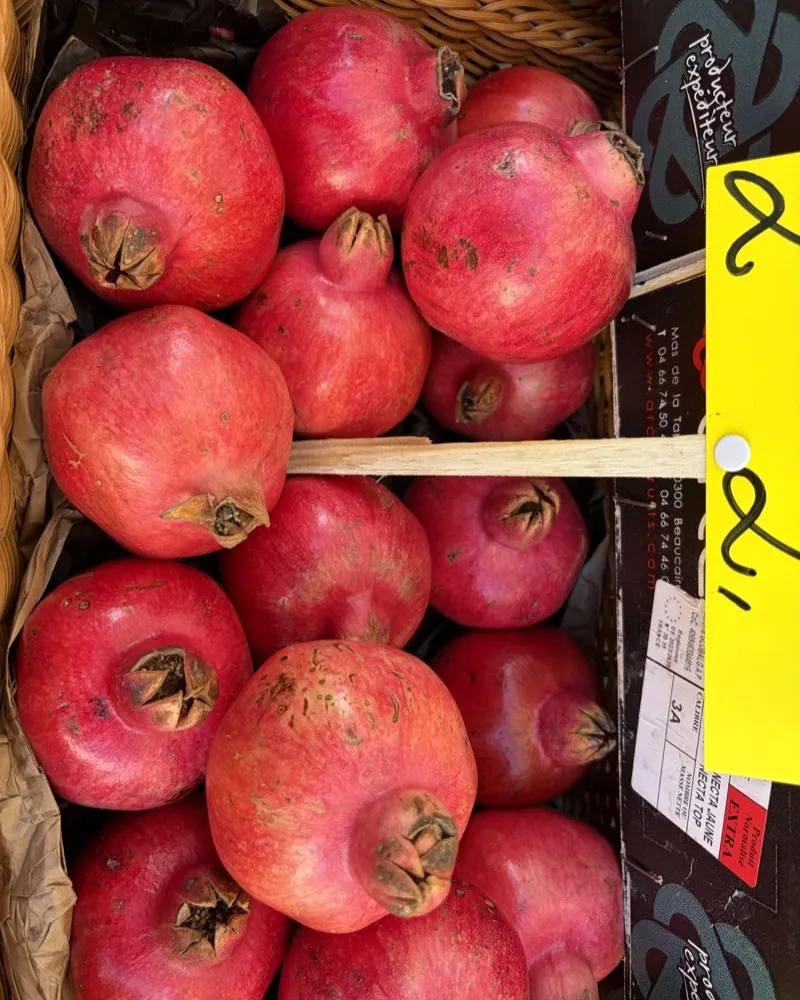 A basket of plump pomegranates at the Kube's Früchtetreff stall at the Bötzowmarkt.