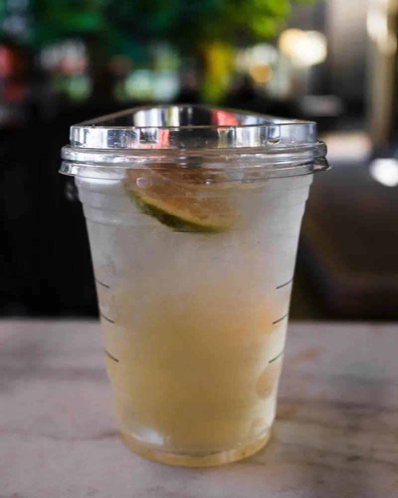 A refreshing drink with lime and ice in a cup.