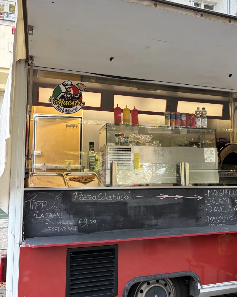 The il Maestro van at the Bötzowmarkt with a wood-fired oven and a menu board, pizza and lasagne on it.